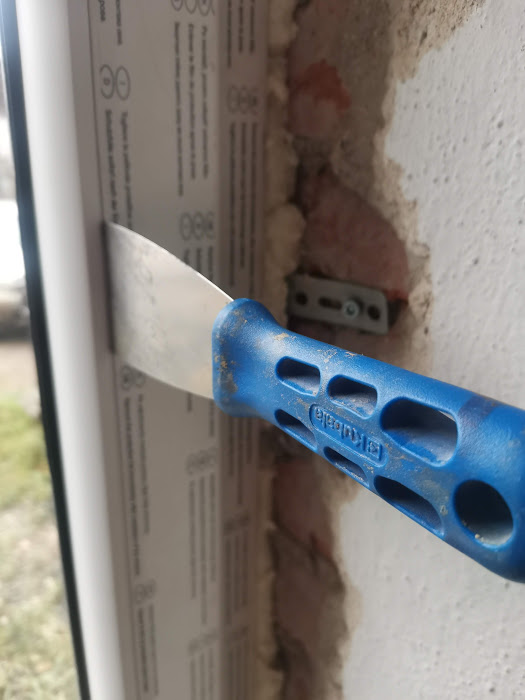 Zasunutí špachtle mezi rám okna a zasklívací lištu